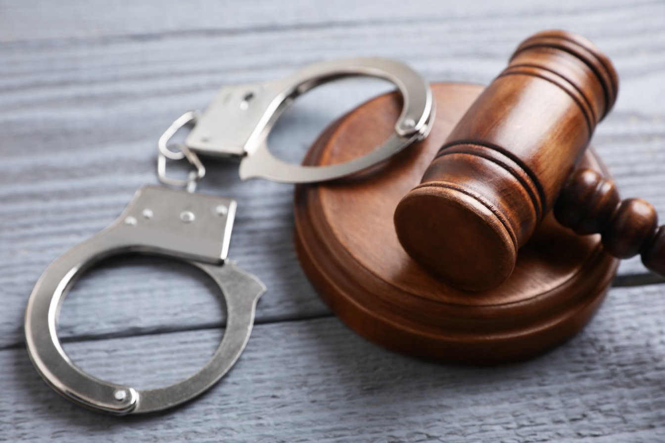 Gavel and Handcuffs on Grey Wooden Table, Closeup. Criminal Law